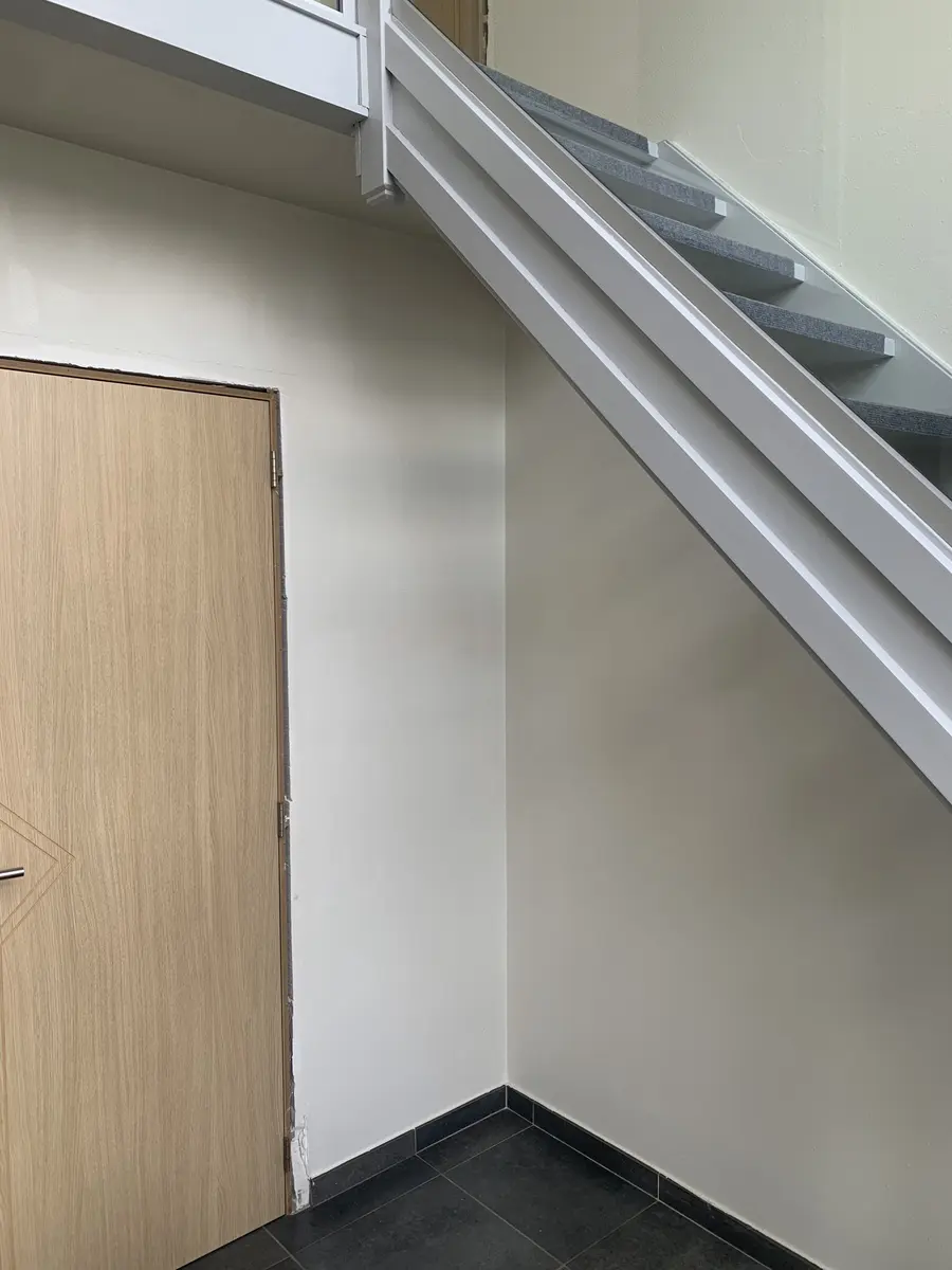 Strak geschilderde wand bij een trap